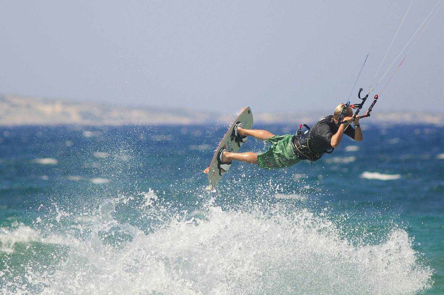 A kitesurfer on flat turquoise water
