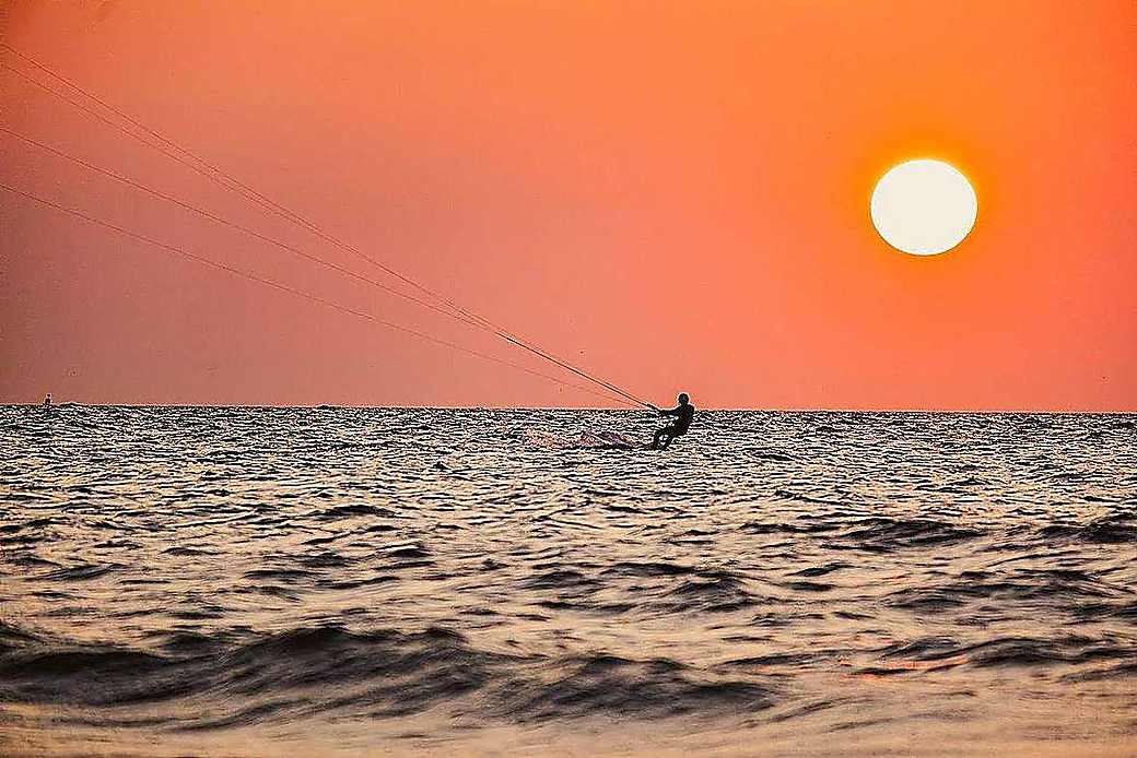 Kitesurfers riding at sunset on Zanzibar beach